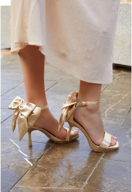 Sandalias doradas de invitada con lazo XL al tobillo