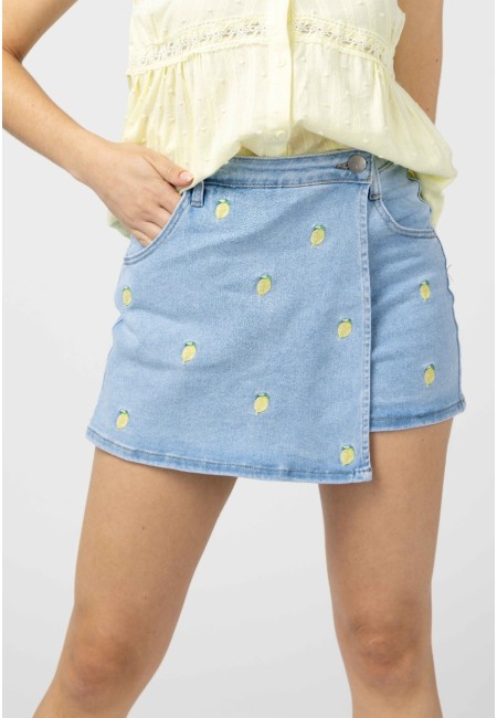 arte delantera de una falda pantalón vaquera azul claro con bordado de limones, combinada con blusa amarilla.