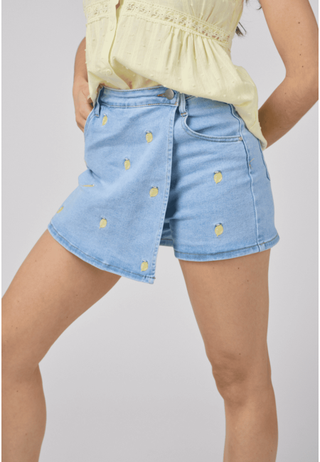 Falda pantalón vaquera con bordado de limones en vista lateral, mostrando el detalle cruzado del diseño
